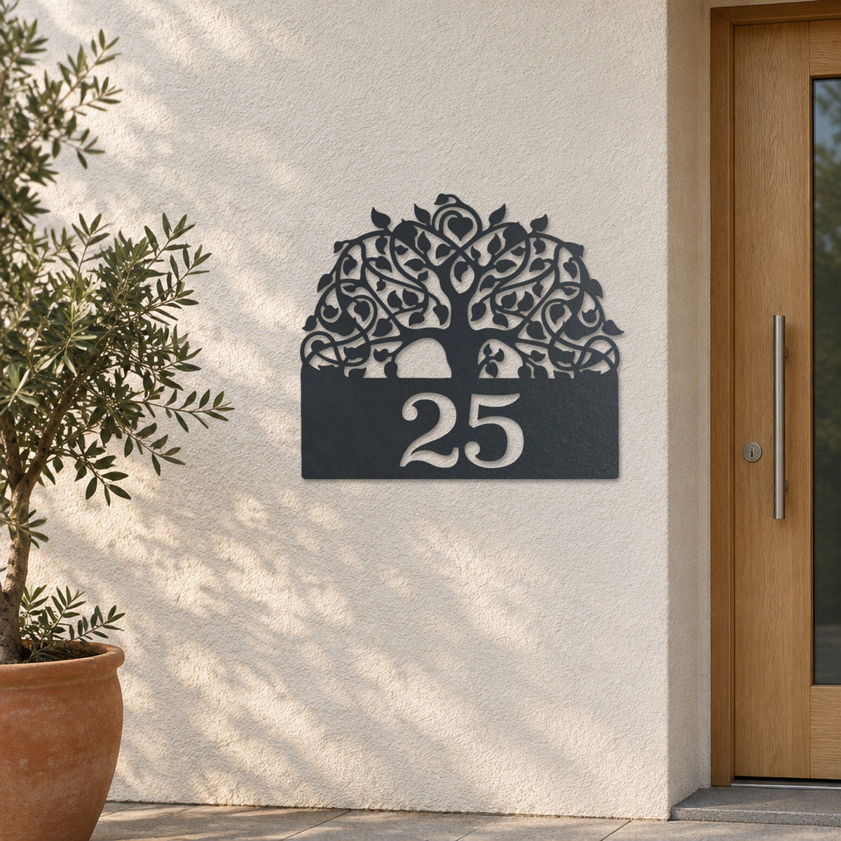 Plăcuță cu număr de casă din inox, personalizată – Arborele vieții cu număr „25” pe un perete tencuit deschis la culoare, inox antracit RAL 7016 · MOHAVE