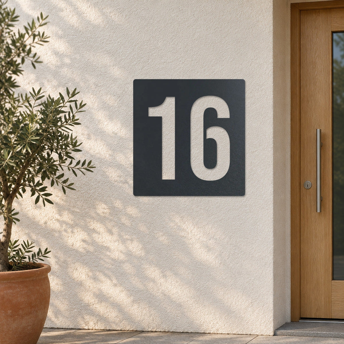 Plăcuță cu număr de casă personalizată din inox – Plăcuță cu număr de casă „16” pe un perete tencuit deschis la culoare, inox vopsit antracit RAL 7016 · MOHAVE