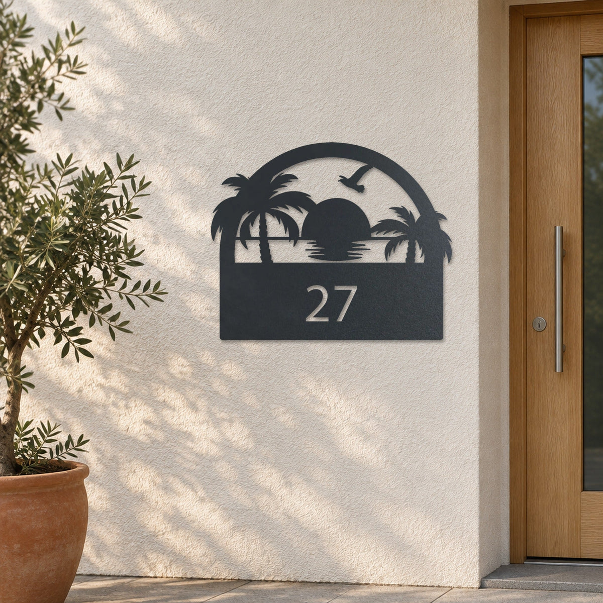 Plăcuță cu număr de casă din inox, personalizată – Plăcuță pentru casă cu apus de soare și număr „27” pe un perete tencuit deschis la culoare, inox vopsit antracit RAL 7016 · MOHAVE