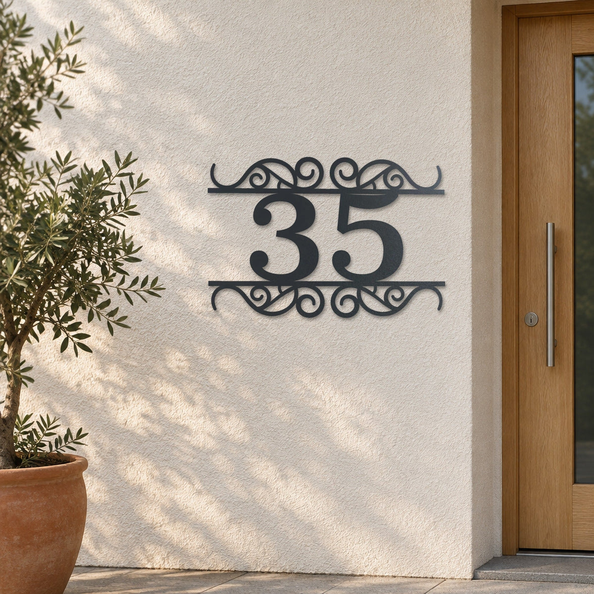 Plăcuță cu număr de casă din inox, personalizată – Număr de casă Ornamentat „35” pe un perete tencuit deschis la culoare, inox antracit RAL 7016 · MOHAVE